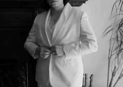 A woman wearing a white suit poses for the camera, exuding elegance in Chicago, IL