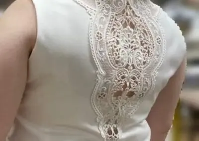 A woman in a white lace-back dress stands elegantly in Chicago, IL