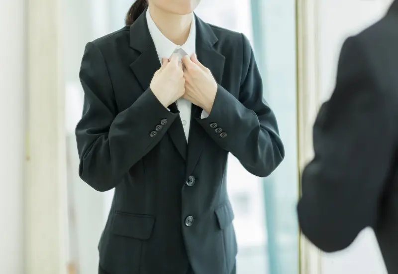 A woman is styling her tuxedo suit made by Richard Bennett Custom Tailors in Chicago, IL