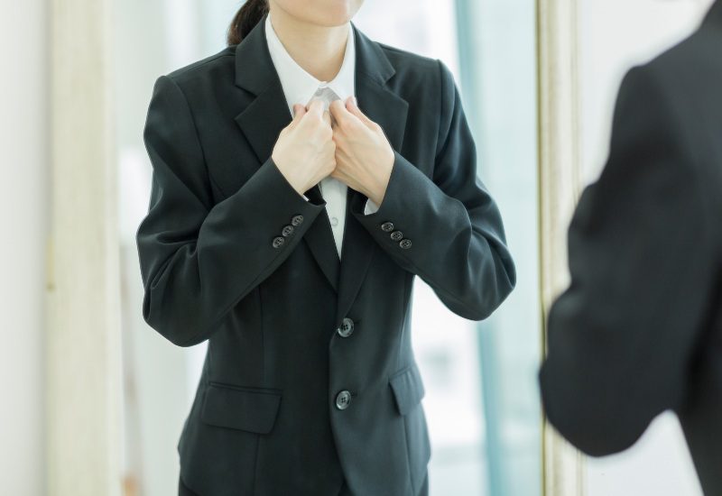 A woman is styling her tuxedo suit made by Richard Bennett Custom Tailors in Chicago, IL